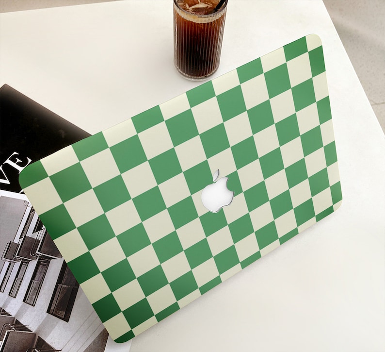 Puede incluir: Piel de port&aacute;til a cuadros verdes y blancos con un logotipo de Apple.