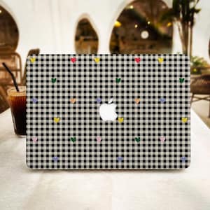 Può includere: Una pelle per laptop a quadri vichy in bianco e nero con adesivi a forma di cuore colorati. La pelle per laptop è progettata per adattarsi a un laptop standard.