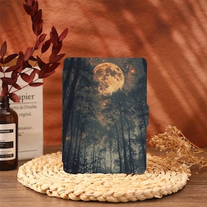 Puede incluir: Una funda de teléfono negra con una luna llena y una escena de bosque. La luna es de color amarillo brillante y el bosque es oscuro con árboles altos.