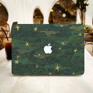 Op de afbeelding: Een groene en gouden laptop skin met een camouflagepatroon en gouden sterren. Het Apple-logo is zichtbaar op de skin.