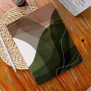 Peut inclure: Une couverture de carnet de notes de conception abstraite verte et brune avec des lignes blanches. La couverture a un aspect texturé, semblable à une aquarelle.