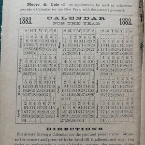 May include: An antique calendar page from 1882, featuring a grid layout with months and dates. The text includes "Particular Notice!!" and instructions for use. The paper has a vintage, aged appearance.