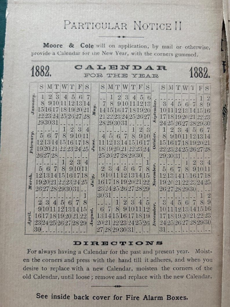 May include: An antique calendar page from 1882, featuring a grid layout with months and dates. The text includes "Particular Notice!!" and instructions for use. The paper has a vintage, aged appearance.