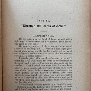 May include: Open book page with text from "A Wanderer in the Spirit Lands." The text includes the title "Through the Gates of Gold" and Chapter XXVII. The paper has a beige tone with black text.