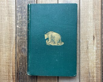 May include: A green hardcover book with a gold illustration of a bear on the front cover.