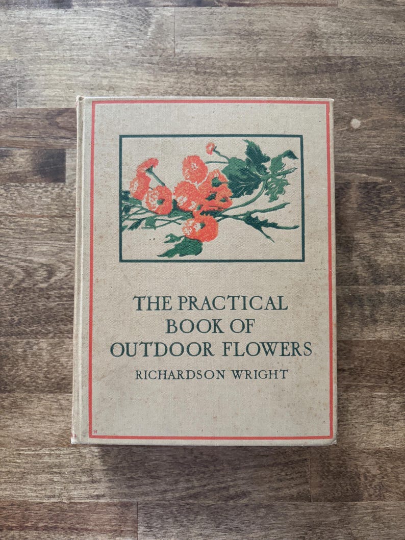 May include: A hardcover book titled The Practical Book of Outdoor Flowers by Richardson Wright. The beige cover features a rectangular illustration of orange flowers with green leaves, enclosed by a thin red border line on the front panel.