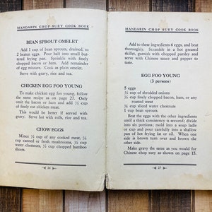 Pu&ograve; includere: Pagine aperte di un libro di cucina con ricette di Mandarin Chop Suey. La pagina sinistra presenta le ricette per Omelette di germogli di fagioli, Chicken Egg Foo Young e Chow Eggs. La pagina destra ha le istruzioni per Egg Foo Young.