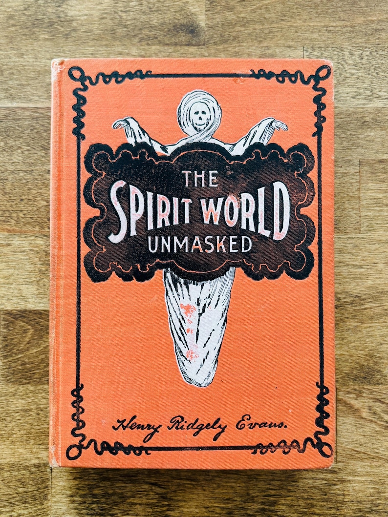 May include: An orange book titled "The Spirit World Unmasked" with a black and white illustration of a ghost on the cover. The book has decorative black borders and the author's name, Henry Ridgely Evans, is printed at the bottom.