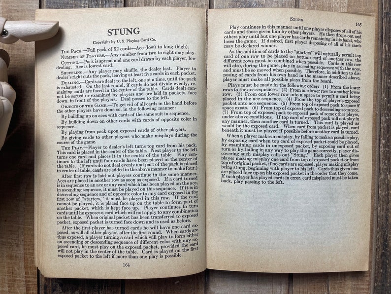 Puede incluir: Una p&aacute;gina de un libro antiguo con instrucciones para jugar al juego de cartas "Stung". El texto describe las reglas del juego, incluyendo c&oacute;mo repartir las cartas, construir secuencias y manejar los errores.