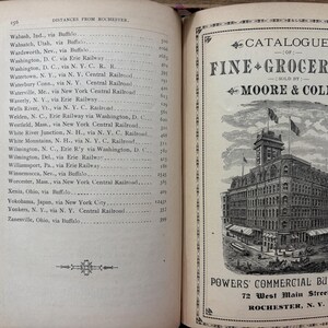 May include: An open book with a page titled "DISTANCES FROM ROCHESTER" and a catalog for "FINE GROCERIES" sold by Moore & Cole. The catalog features an illustration of the Powers Commercial Building in Rochester, N.Y.