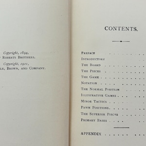 May include: Open book pages with text. The left page shows copyright information from 1894 and 1921. The right page displays a table of contents with titles like "The Board" and "The Pieces".