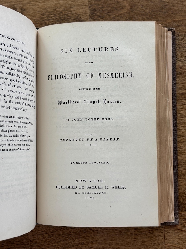 Puede incluir: Libro abierto con el t&iacute;tulo "SIX LECTURES ON THE PHILOSOPHY OF MESMERISM" de John Bovee Dods, publicado en Nueva York en 1875. Las p&aacute;ginas est&aacute;n envejecidas, con texto visible y una cubierta azul oscuro.