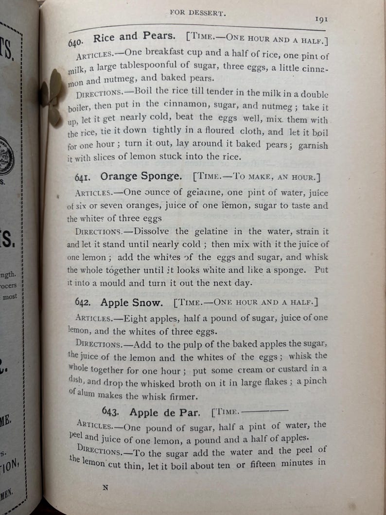 May include: Open book page with text from a vintage cookbook. The page features recipes for desserts like Rice and Pears, Orange Sponge, Apple Snow, and Apple de Par. The text is in black ink.