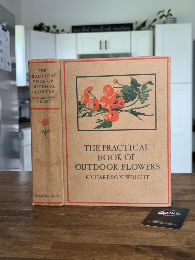 May include: A tan hardcover book titled The Practical Book of Outdoor Flowers by Richardson Wright. The cover features a rectangular illustration of orange flowers with green leaves, a red border, and black text. The spine includes the title and author.