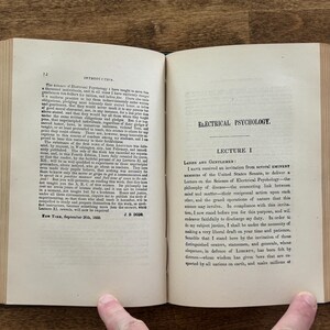 Puede incluir: Un libro antiguo abierto con p&aacute;ginas envejecidas y amarillentas. La p&aacute;gina izquierda muestra la palabra "INTRODUCTION" en la parte superior, mientras que la p&aacute;gina derecha dice "ELECTRICAL PSYCHOLOGY". El texto est&aacute; en tinta negra y el lomo del libro es visible.