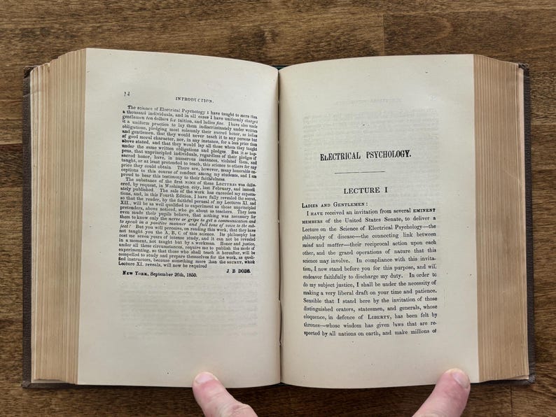 Puede incluir: Un libro antiguo abierto con p&aacute;ginas envejecidas y amarillentas. La p&aacute;gina izquierda muestra la palabra "INTRODUCTION" en la parte superior, mientras que la p&aacute;gina derecha dice "ELECTRICAL PSYCHOLOGY". El texto est&aacute; en tinta negra y el lomo del libro es visible.