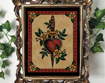 May include: A framed print of a traditional tattoo design featuring a red heart pierced by a dagger with a green handle and yellow flowers. The background is a black and red pattern.