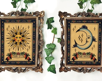 May include: Two framed prints with gold ornate frames. The prints feature vintage-style illustrations of the sun and moon with the text "The Sun" and "The Moon" below each image.
