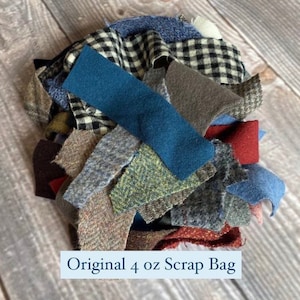 K&ouml;nnte beinhalten: Ein Haufen Stoffreste in verschiedenen Farben und Mustern, darunter Blau, schwarz-wei&szlig; kariert und brauner Tweed. Der Text "Original 4 oz Scrap Bag" ist unten sichtbar.
