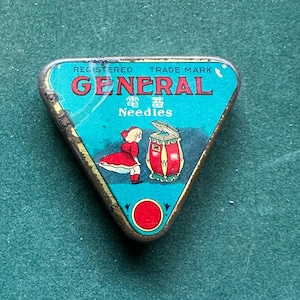 May include: A vintage triangular metal needle tin with a teal background. The tin features the word "GENERAL" in red, Japanese text, and an illustration of a girl in a red dress and a red and gold machine.