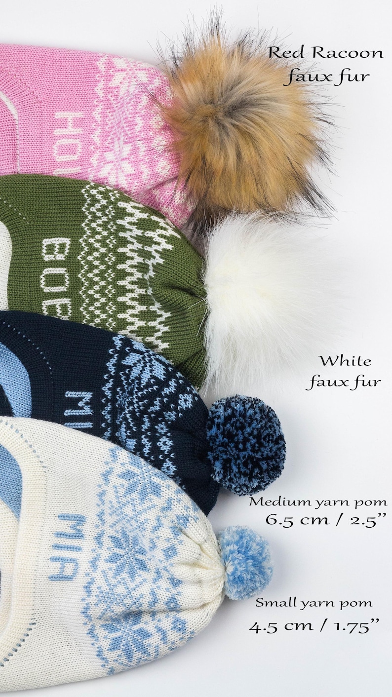 Puede incluir: Cuatro gorros de punto con patrones de copos de nieve y nombres. El gorro superior tiene un pomp&oacute;n de piel sint&eacute;tica de mapache rojo, el segundo uno de piel sint&eacute;tica blanca, el tercero uno de lana mediano de 6,5 cm y el inferior uno peque&ntilde;o de 4,5 cm.