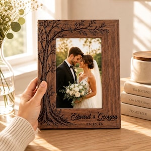 May include: A rectangular wooden picture frame featuring a laser-engraved tree design with two birds on a branch. The frame displays a photograph of a couple and includes the engraved text Edward & Georgia and the date 06.25.26 at the bottom.