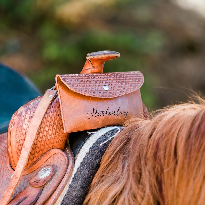K&ouml;nnte beinhalten: Ein brauner Ledersattel mit einer braunen Ledertasche. Die Tasche tr&auml;gt die Aufschrift "Starkenburg".