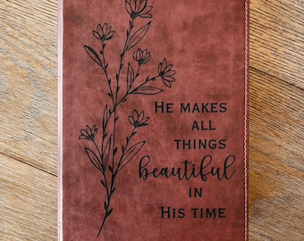 Könnte beinhalten: Ein weinrotes Buch mit dem Text "HE MAKES ALL THINGS beautiful IN HIS TIME" und der Bibelstelle "Prediger 3:11". Auf der linken Seite des Einbands befindet sich ein Blumendesign.