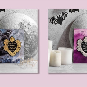K&ouml;nnte beinhalten: Zwei Karten mit einem schwarzen und wei&szlig;en Herzdesign mit dem Text "Save The Date" und "Renee & Gerald" auf schwarzem Hintergrund mit goldener Umrandung. Die Karten liegen auf einer wei&szlig;en Oberfl&auml;che mit Kerzen und einem mondartigen Objekt im Hintergrund.