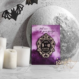 Puede incluir: Un anuncio de boda morado y dorado con un marco decorativo y el texto "Put me on your fridge" y "Levi & Kaytie 04.01.2023".