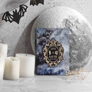 Puede incluir: Una tarjeta de anuncio de boda azul y negra con un marco dorado adornado. El texto dice "Put me on your fridge" y "Levi & Kaytie 04.01.2023".