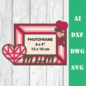 May include: A pink and brown layered photo frame with a heart design and the word "mom" in a decorative font. The frame is 6 inches by 4 inches or 15 centimeters by 10 centimeters.