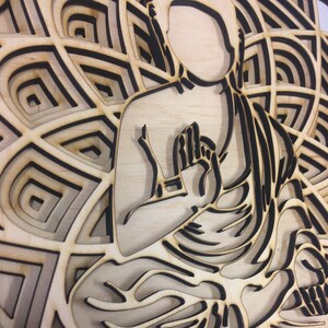 May include: A wooden wall art piece featuring a detailed silhouette of a person in a meditative pose, surrounded by a mandala design.