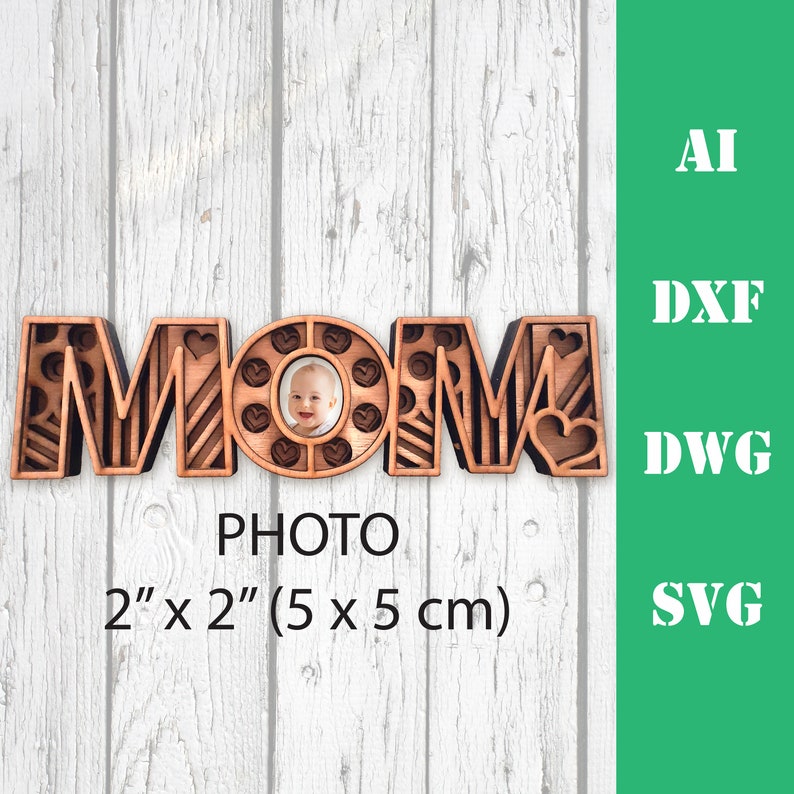 May include: Wooden cutout of the word "MOM" with a photo frame in the "O". The frame is 2 inches by 2 inches (5 cm by 5 cm).