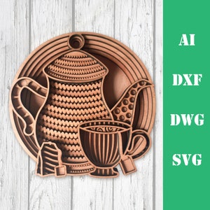 May include: A wooden cutout of a teapot and teacup with tea bags. The design is intricate and detailed, with a layered effect. The teapot and teacup are brown and have a patterned design.