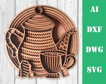 May include: A wooden cutout of a teapot and teacup with tea bags. The design is intricate and detailed, with a layered effect. The teapot and teacup are brown and have a patterned design.
