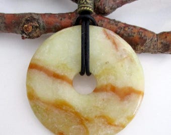 May include: A round, light green and orange stone pendant with a central hole, strung on a black leather cord. The pendant has a marbled appearance with streaks of orange and yellow. A decorative bronze-colored bead accents the cord.