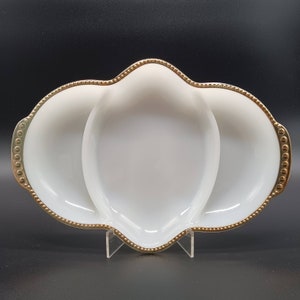 May include: White ceramic serving dish with three sections, each with a gold beaded rim. The dish is shaped like a heart with three rounded sections.