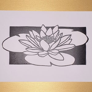 May include: A black and white line art print of a water lily with a single flower and leaf.