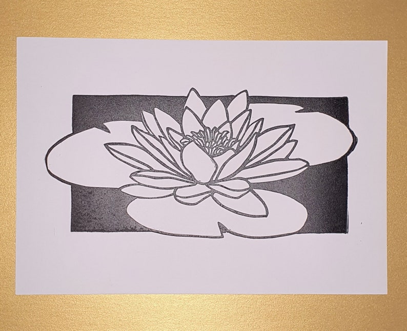 May include: A black and white line art print of a water lily with a single flower and leaf.