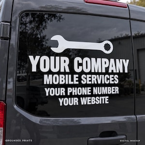 May include: A white vinyl decal applied to the rear window of a dark gray van. The design features a wrench icon above the text: YOUR COMPANY, MOBILE SERVICES, YOUR PHONE NUMBER, and YOUR WEBSITE in a bold, sans-serif font.