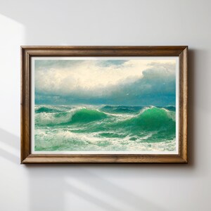 Puede incluir: Una obra de arte enmarcada que representa un paisaje marino con grandes olas de color verde esmeralda rompiendo bajo un cielo nublado. La pintura está enmarcada en un marco de madera marrón oscuro, agregando un toque clásico. Las olas son el foco principal.