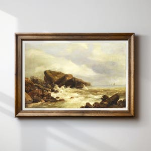 May include: A framed landscape painting depicts a rocky coastline with waves crashing against the shore. The artwork features a muted color palette of browns, greens, and blues, with a cloudy sky above. The frame is made of wood.