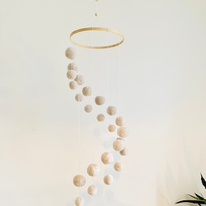 Spiral mobile with pompoms in neutral unisex color