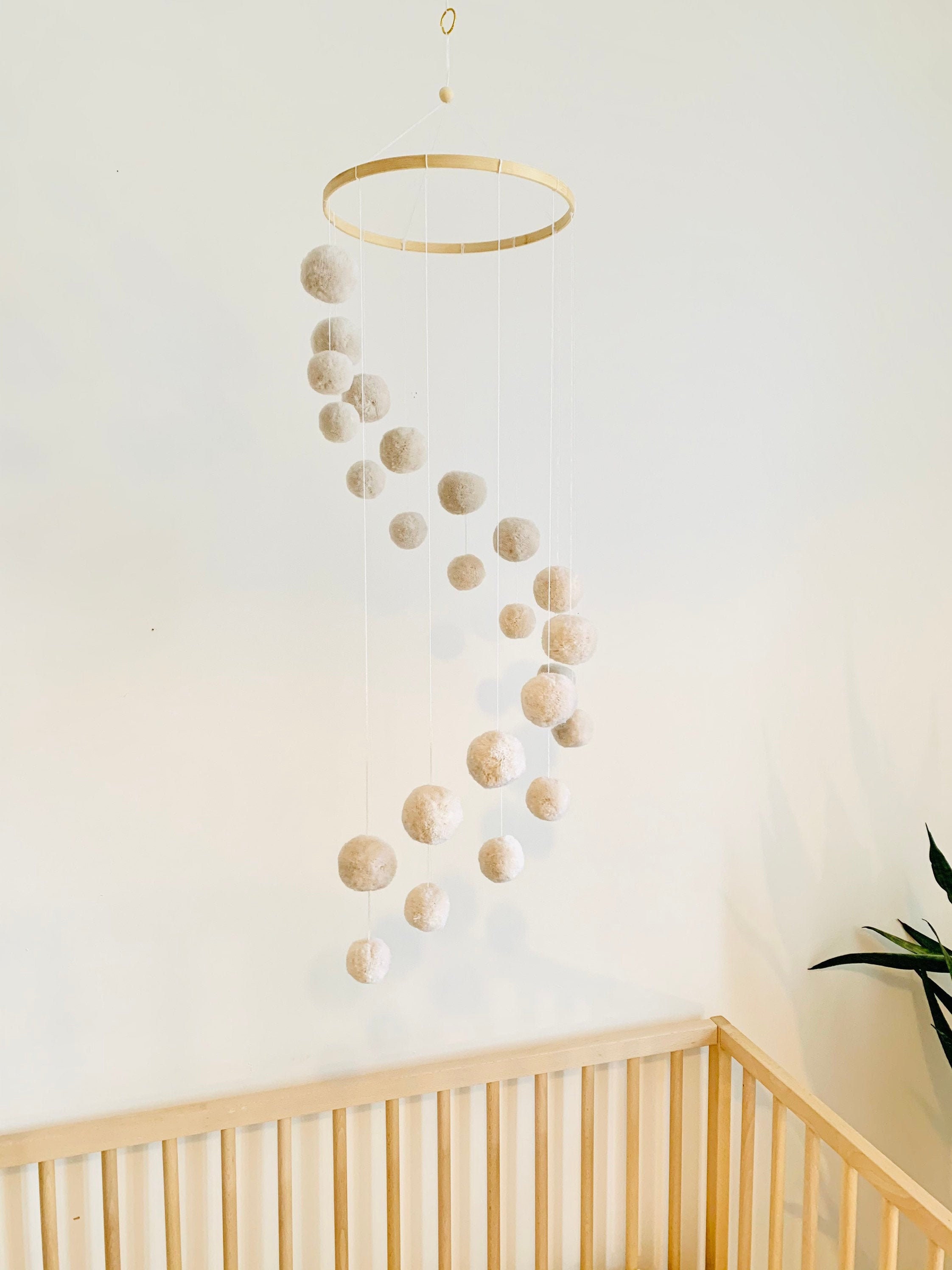 Spiral mobile with pompoms in neutral unisex color
