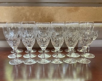Puede incluir: Un juego de 15 copas de vino de cristal transparente con un diseño de cristal tallado. Las copas están dispuestas en tres filas de cinco.