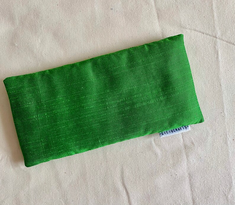 May include: Green eye pillow with a white label that says "Cicicrafts".