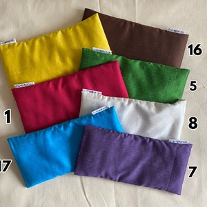 May include: Ten different colored eye pillows, each with a number label. The pillows are made of a soft, textured fabric and are perfect for relaxation.