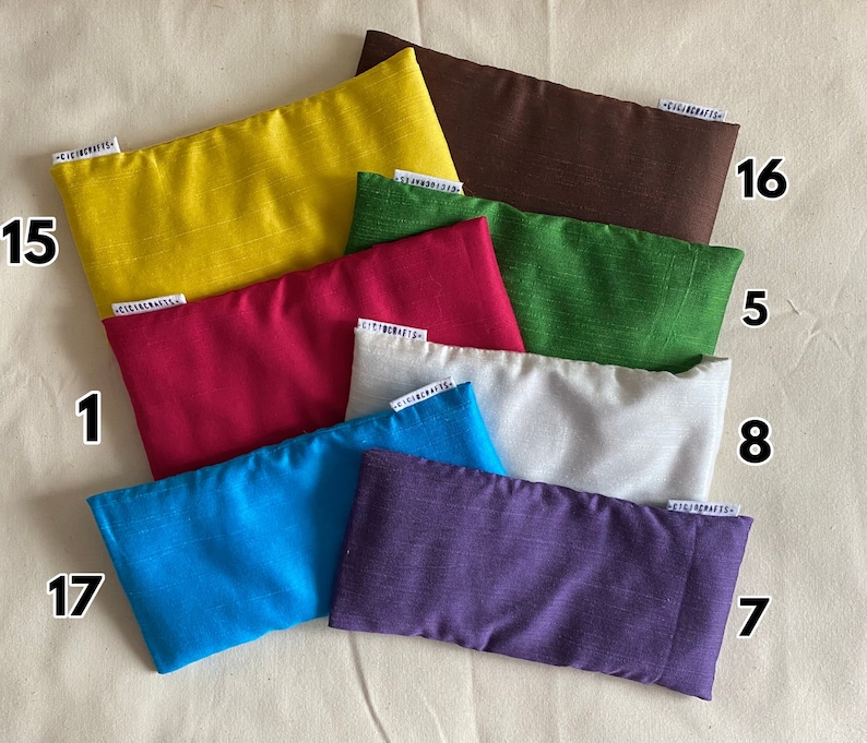 May include: Ten different colored eye pillows, each with a number label. The pillows are made of a soft, textured fabric and are perfect for relaxation.