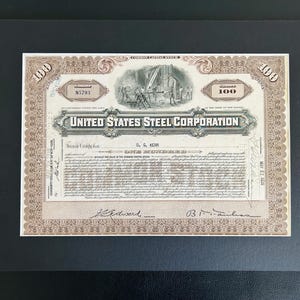 May include: A framed United States Steel Corporation stock certificate. The certificate is printed in black and beige with decorative borders and illustrations. The text includes the company name and the number 100.